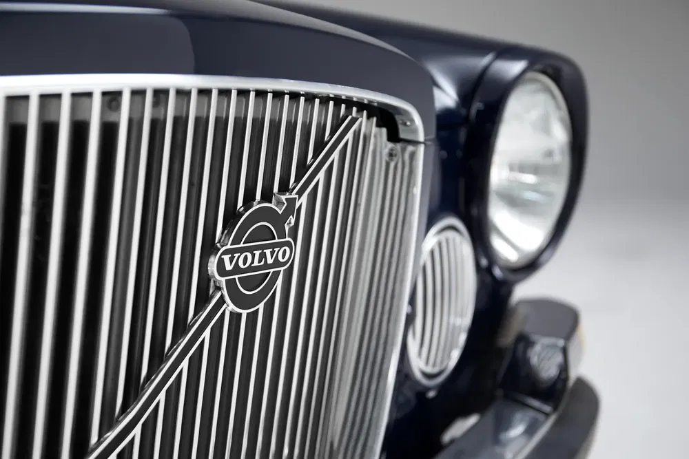 Close-up van de grille van een klassieke Volvo met logo, elegant en tijdloos design.