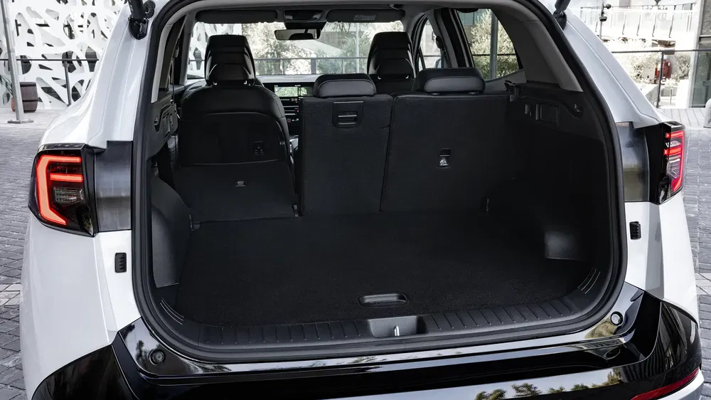 Coffre spacieux d'un SUV moderne blanc avec sièges arrière rabattus.