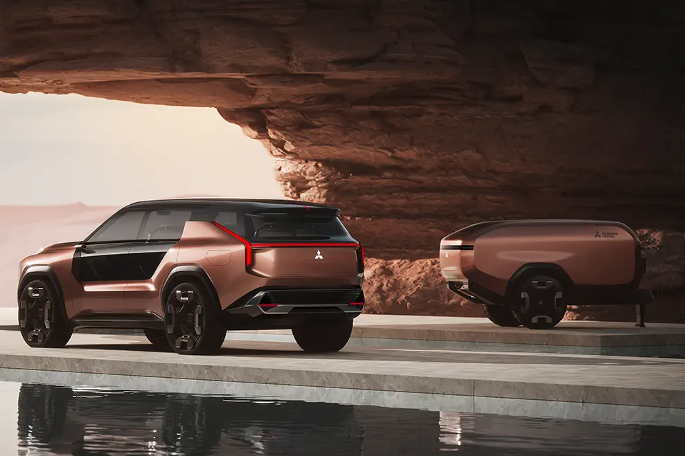 Concept car Mitsubishi dans décor désertique, design futuriste avec remorque assortie.