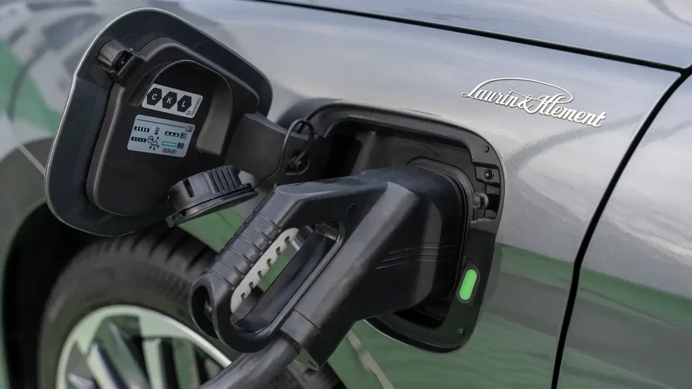 {"fr":"Recharge d'une voiture électrique Volkswagen avec badge Laurin & Klement en gros plan.","nl":"Opladen van een elektrische Volkswagen met Laurin & Klement embleem in close-up."}