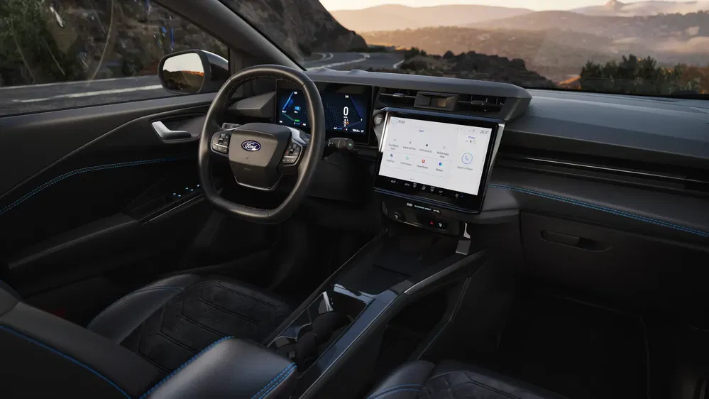 Intérieur moderne de Ford avec écran tactile, volant ergonomique, vue montagne à l'extérieur.