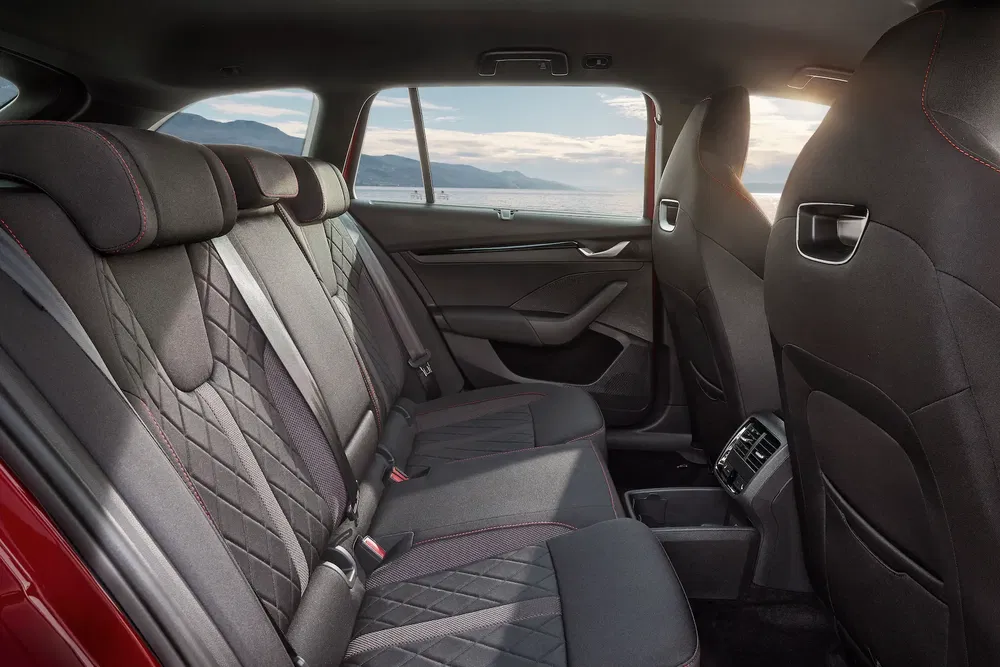 Intérieur arrière spacieux et luxueux d'une Skoda, vue panoramique sur la mer.