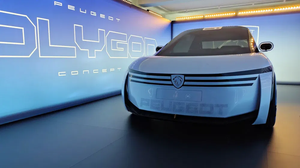 Voiture conceptuelle Peugeot Polygon futuriste exposée à l'avant dans un showroom moderne.