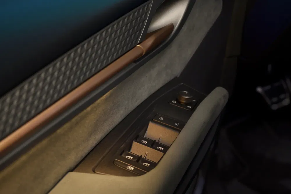 Intérieur de voiture électrique avec commandes de fenêtre et finition élégante en cuir et bois.