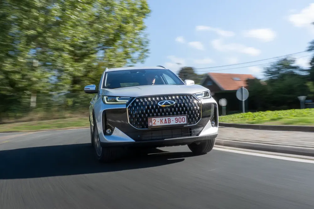 Chery Tiggo 7 Pro SUV roulant sur une route, devant un fond de nature verdoyante.