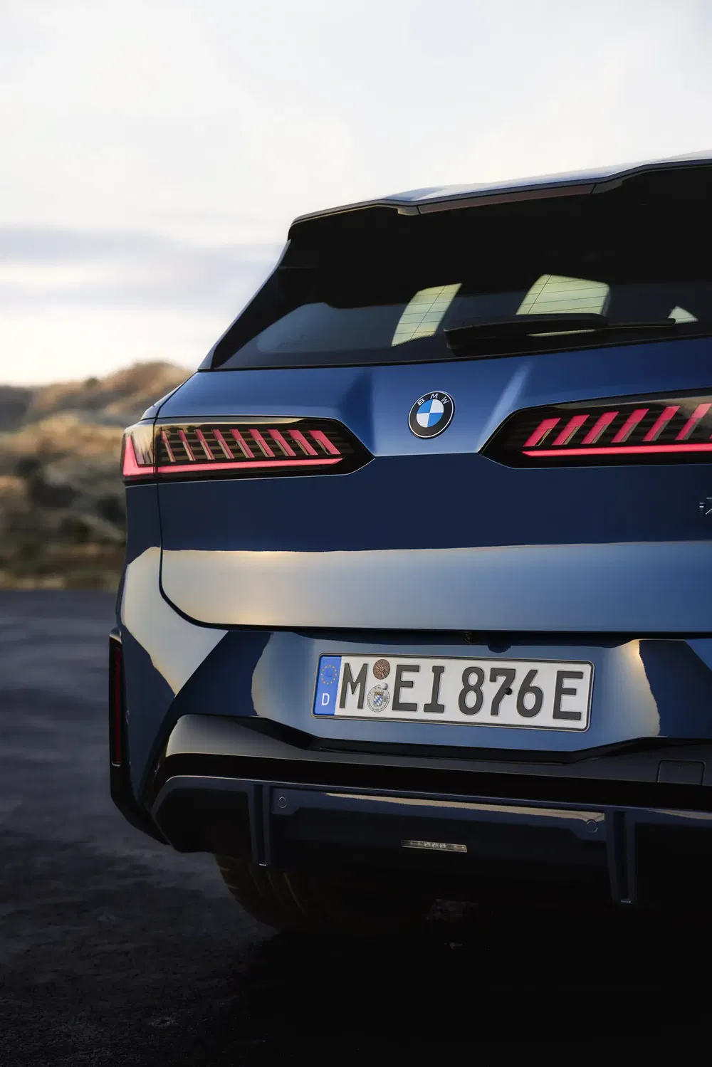 Achteraanzicht van een blauwe BMW iX met moderne achterlichten en Duitse kentekenplaat.