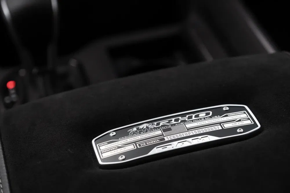 Unieke badgeplaat van RAM Rho-model op suède dashboardinterieur.