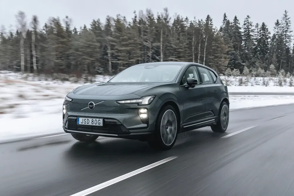 {"fr":"Volvo électrique roulant sur une route enneigée, entourée de forêt hivernale.","nl":"Elektrische Volvo rijdt op besneeuwde weg, omringd door winterbos."}