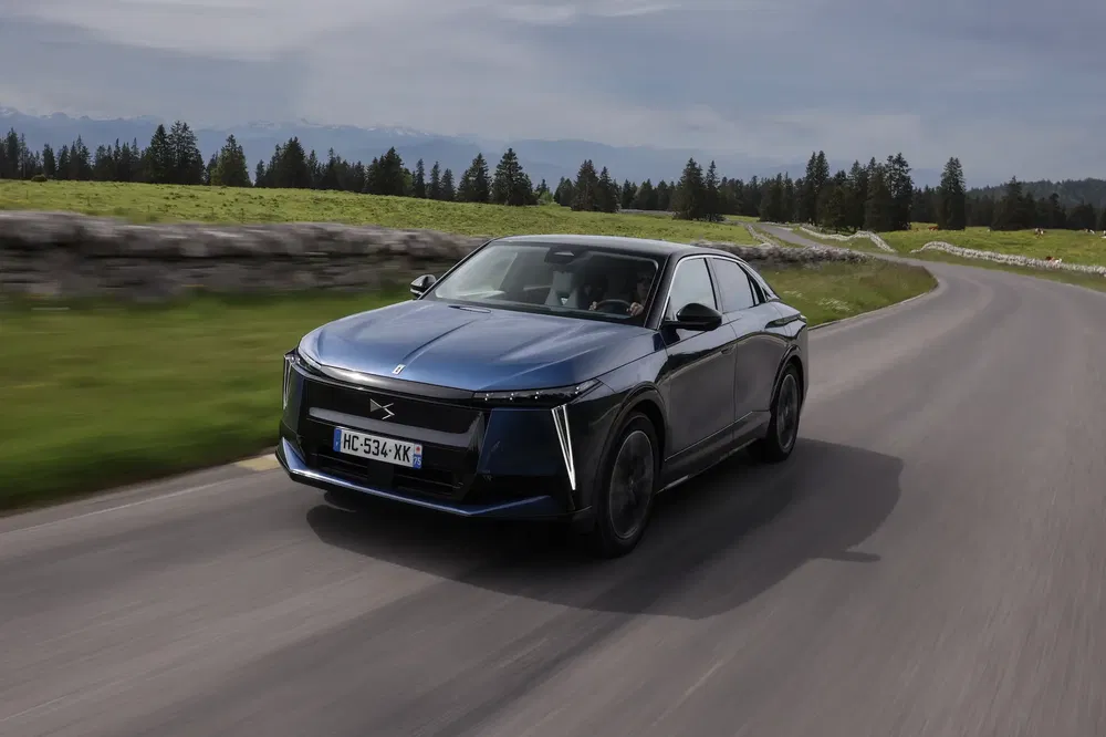 DS dominerend op bergweg, modern design, natuur en Alpenlandschap op de achtergrond.