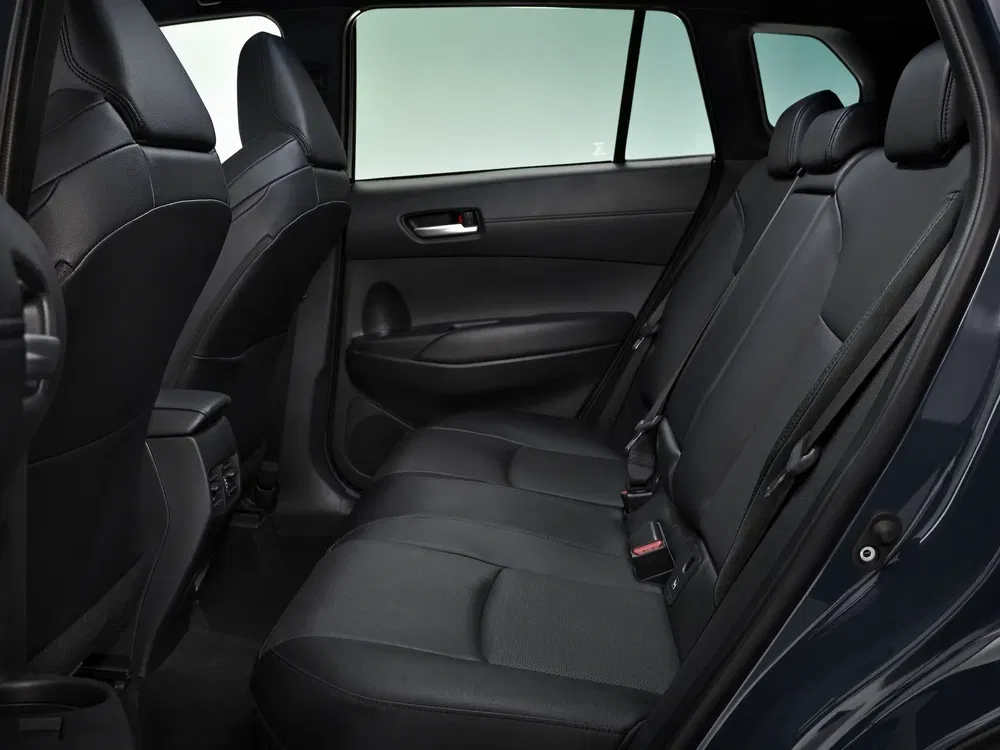 Intérieur de voiture Toyota moderne avec sièges arrière en cuir noir, espace et confort optimisés.
