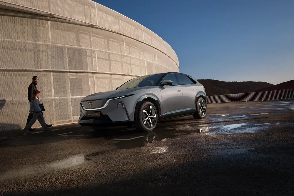 Concept-car électrique Mazda CX-60 stationné devant un bâtiment moderne.