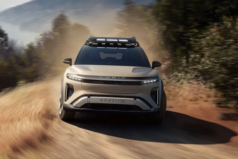 SUV Lucid Gravity roulant sur une route poussiéreuse en milieu rural.