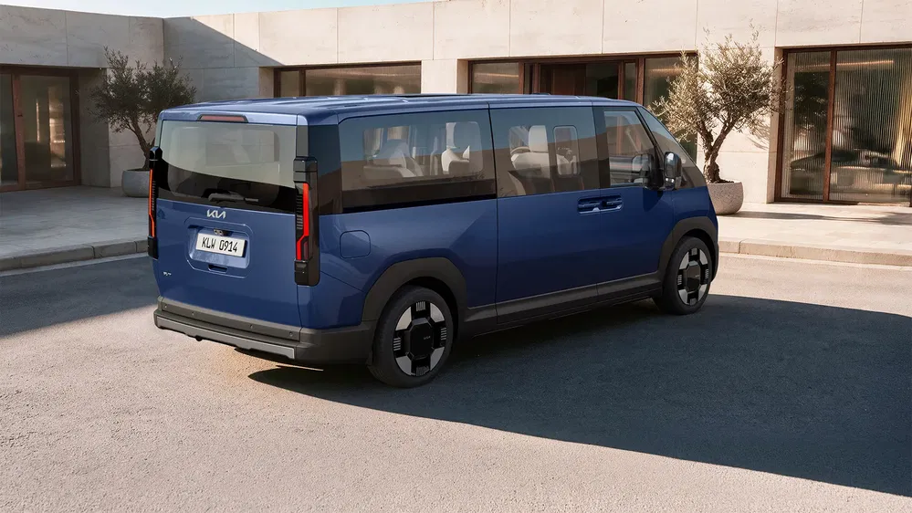 Kia EV9 bleu garée devant un bâtiment moderne, design futuriste et élégant.