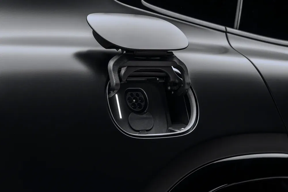 Prise de recharge électrique ouverte sur une voiture noire moderne, conception élégante et futuriste.