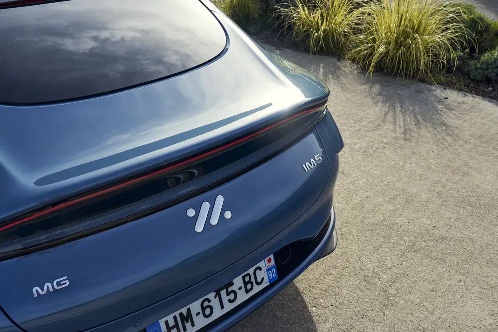 Arrière bleu d'une MG 5 avec plaque française et design aérodynamique moderne.