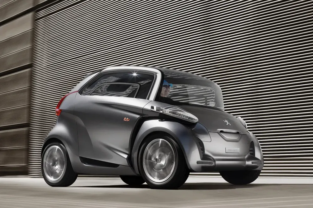 Concept car urbain Peugeot BB1, design futuriste, arrière-plan moderne et industriel.