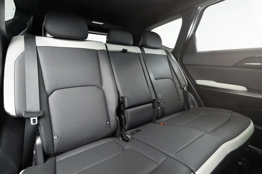 Auto-interieur met zwarte lederen achterstoelen en neerklapbare armleuning.