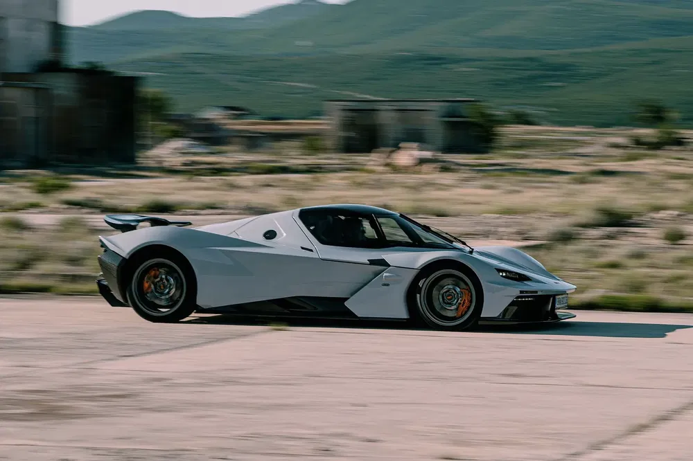 Supercar KTM X-Bow GT-XR grise roulant à grande vitesse dans un paysage désertique.
