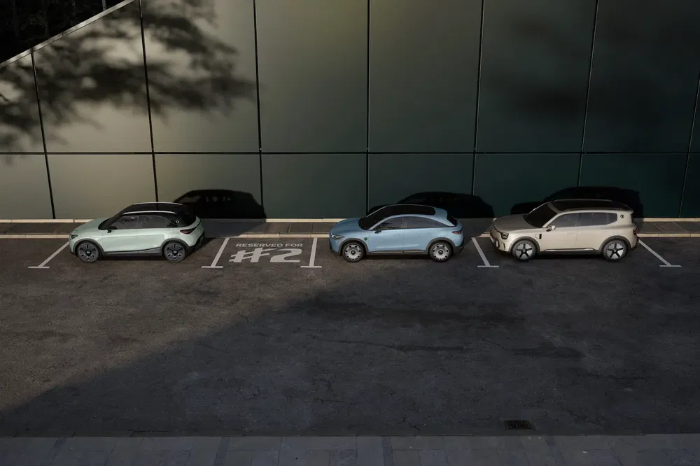 Trois SUV électriques stationnés, avant-gardistes, devant un bâtiment moderne.