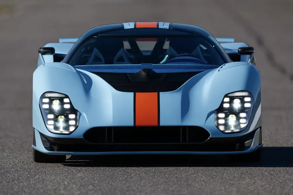 {"fr":"Hypercar Project Vengeance bleue avec bandes oranges sur une piste de course.","nl":"Blauwe hypercar Project Vengeance met oranje strepen op een racebaan."}