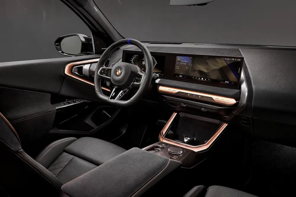 Intérieur luxueux d'une BMW iX avec tableau de bord numérique moderne et finitions élégantes.
