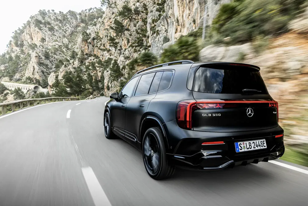 Mercedes-Benz GLB 350 noir sur route de montagne sinueuse, en pleine conduite.