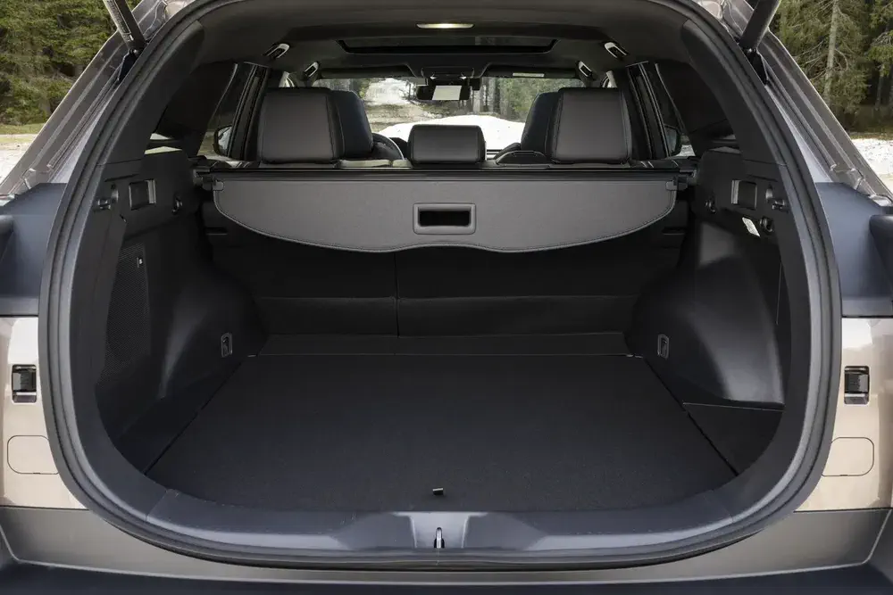 Coffre spacieux d'un SUV moderne avec sièges arrière rabattables et couverture amovible.