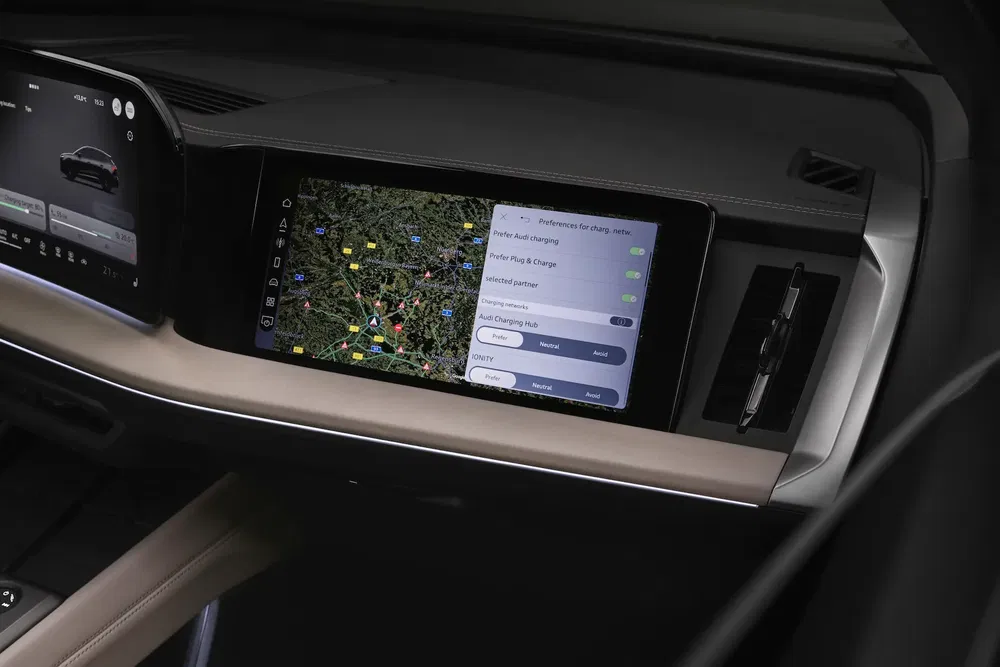 Écran tactile Audi affichant carte GPS et paramètres de recharge dans l'habitacle moderne.