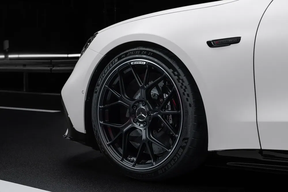 Roue AMG noire sur Mercedes-Benz blanche, avec pneus Michelin détaillés de haute performance.