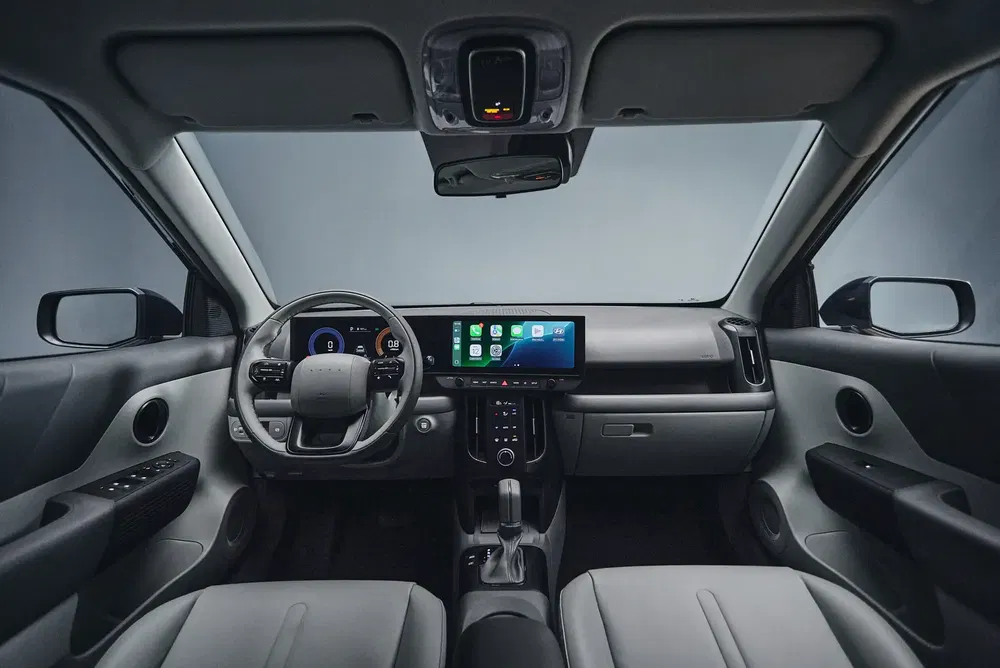 Intérieur moderne de la Volvo EX30 avec écran tactile central large et tableau de bord numérique.