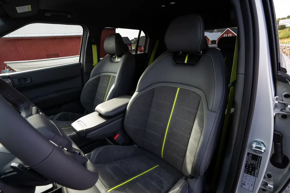 Intérieur Ford moderne avec sièges en cuir noir et détails verts, ambiance élégante et sportive.