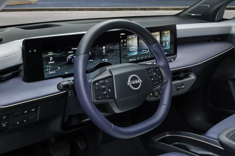 Interieur van een Nissan met geavanceerd digitaal dashboard en multifunctioneel stuurwiel.
